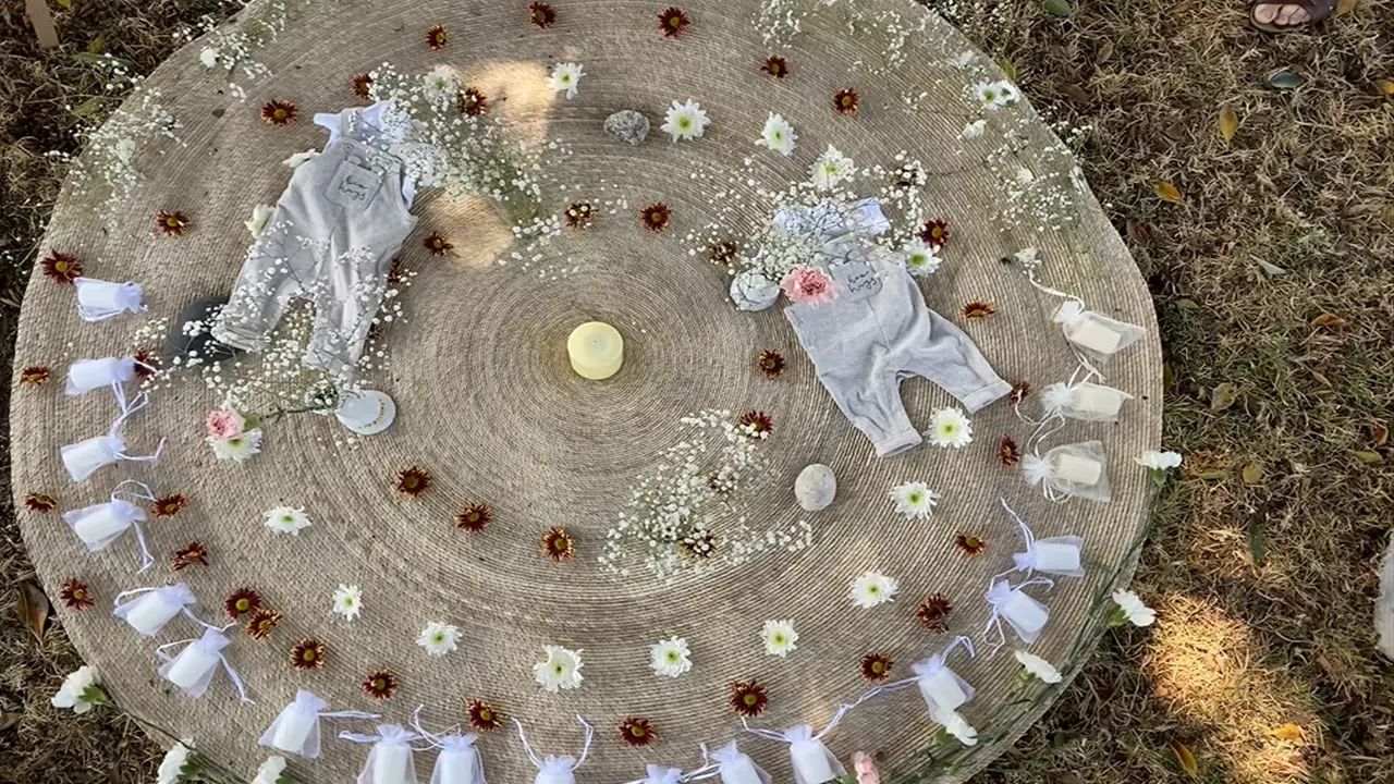 Ceremonia blessing way al aire libre con flores y mujeres acompañando a la embarazada
